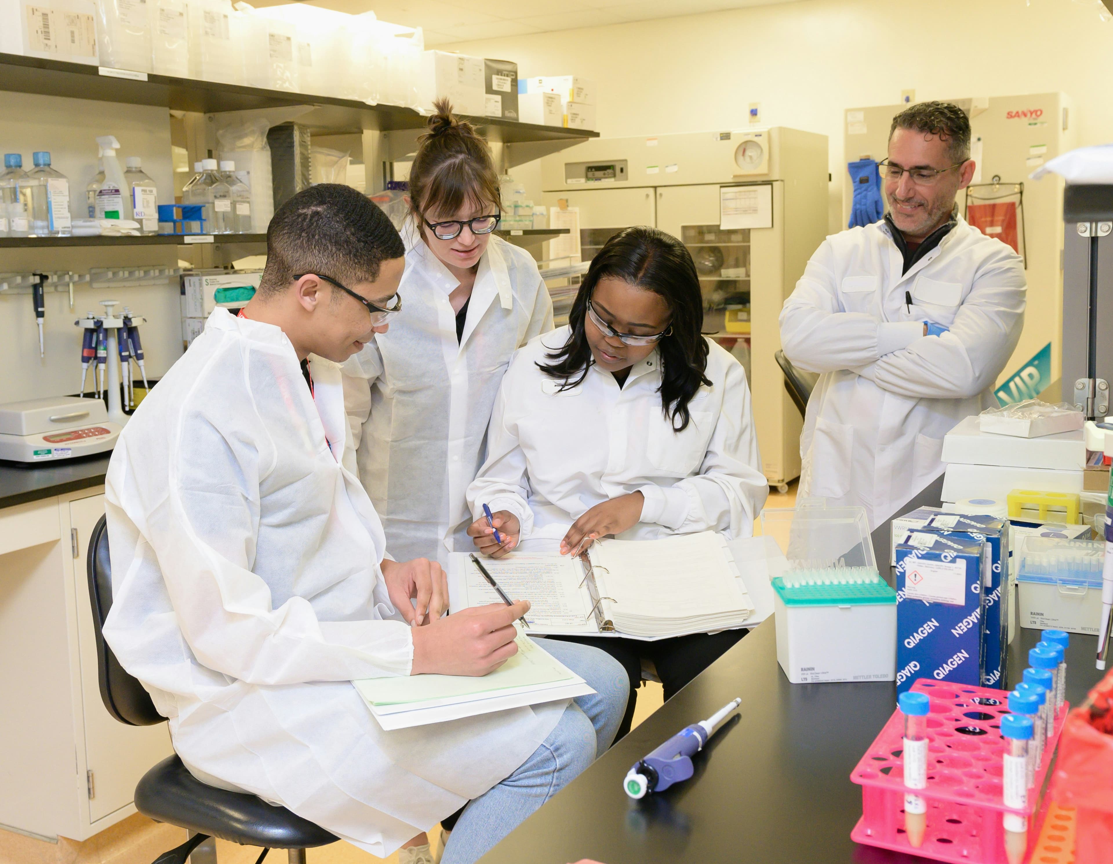 Research team reviewing lab notes together at a laboratory bench