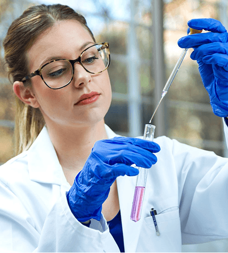 Scientist carefully pipetting a sample into a test tube in the laboratory